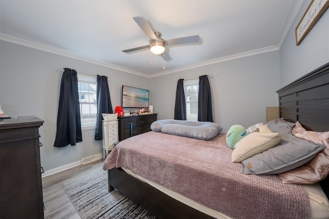 bedroom featuring baseboards, multiple windows, wood finished floors, and crown molding