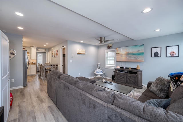 living room featuring ceiling fan, recessed lighting, baseboards, light wood-type flooring, and ornate columns