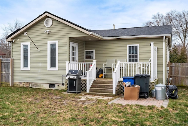 back of property featuring a lawn, roof with shingles, crawl space, fence, and a wooden deck