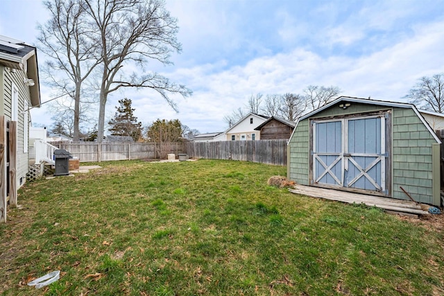 view of yard with a storage shed, an outbuilding, and a fenced backyard