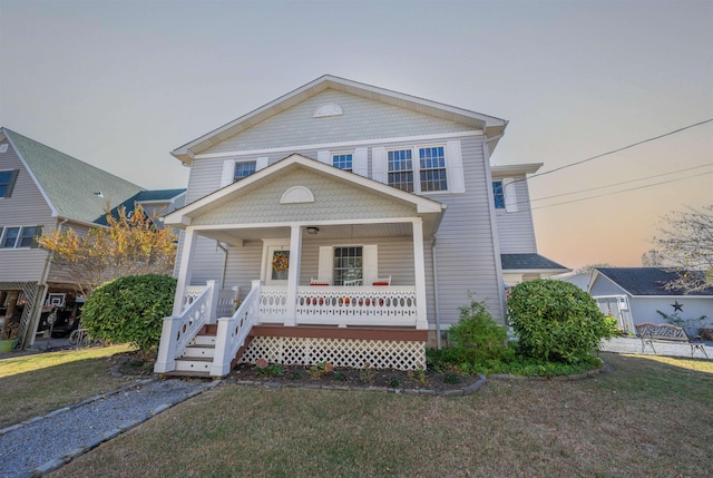 view of front of property with a porch and a yard