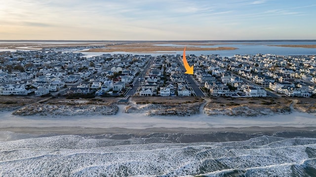 aerial view at dusk featuring a water view