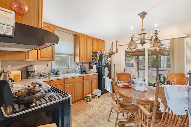 100 Oakdale Ave, Villas, NJ 08251 - kitchen featuring stainless steel gas range, extractor fan, light countertops, hanging light fixtures, and freestanding refrigerator