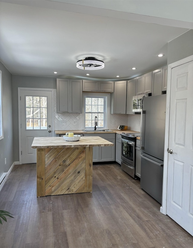 kitchen with stainless steel appliances, a sink, and gray cabinetry