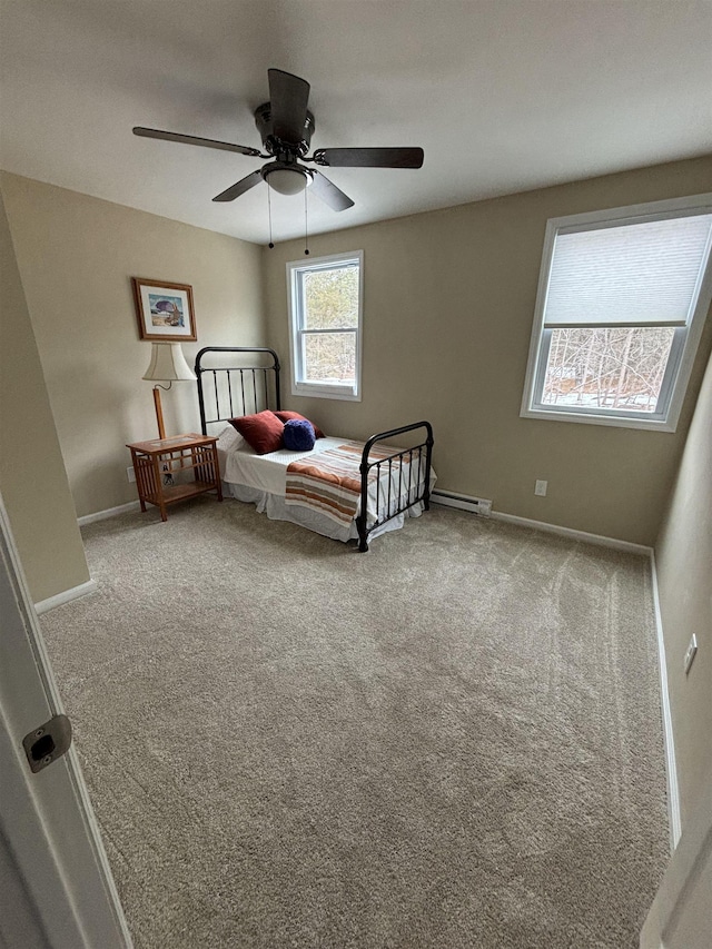 unfurnished bedroom featuring a ceiling fan, carpet, baseboard heating, and baseboards