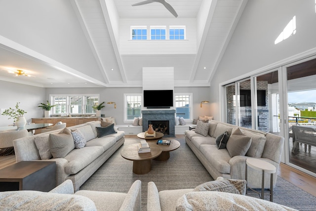 living room featuring hardwood / wood-style floors, high vaulted ceiling, ceiling fan, and beam ceiling