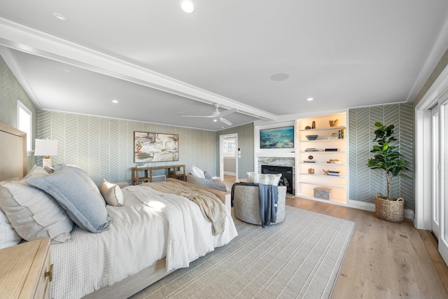 bedroom with ceiling fan, beamed ceiling, and light hardwood / wood-style floors