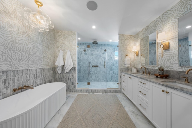 bathroom with vanity, tile walls, independent shower and bath, and a chandelier