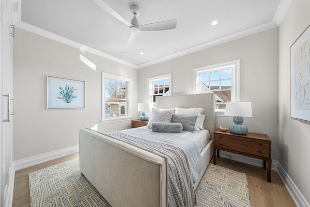 bedroom with hardwood / wood-style flooring, ceiling fan, and ornamental molding