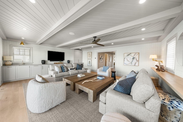 living room with beam ceiling, ceiling fan, sink, and light hardwood / wood-style floors