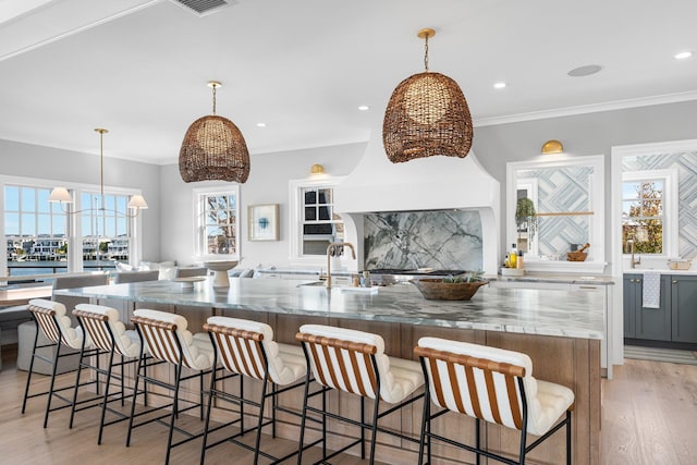 kitchen featuring a spacious island, a kitchen bar, hanging light fixtures, and tasteful backsplash