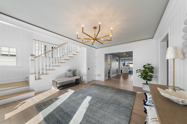 interior space with a chandelier, dark hardwood / wood-style flooring, and ornamental molding