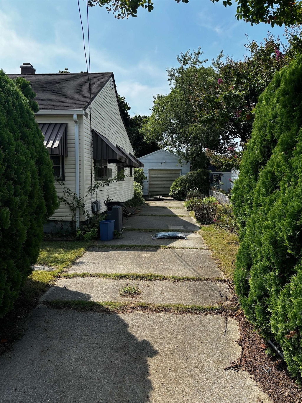 view of side of property featuring a garage and an outbuilding