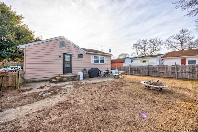 back of house with an outdoor fire pit and a patio