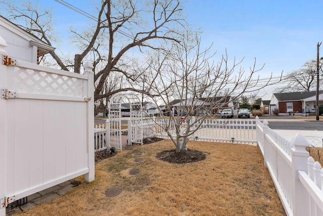 view of yard featuring a fenced backyard and a residential view