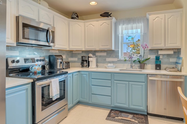 kitchen featuring white cabinets, a sink, stainless steel appliances, and light countertops