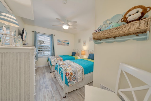 bedroom with light wood finished floors, ceiling fan, and baseboards