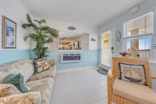 living room with a ceiling fan, visible vents, and light tile patterned floors