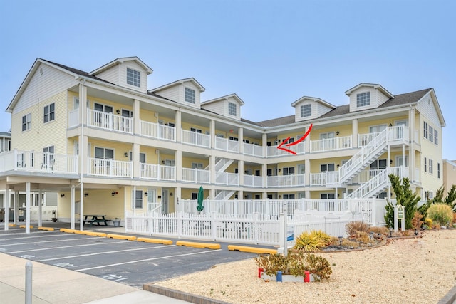 view of property featuring uncovered parking and fence