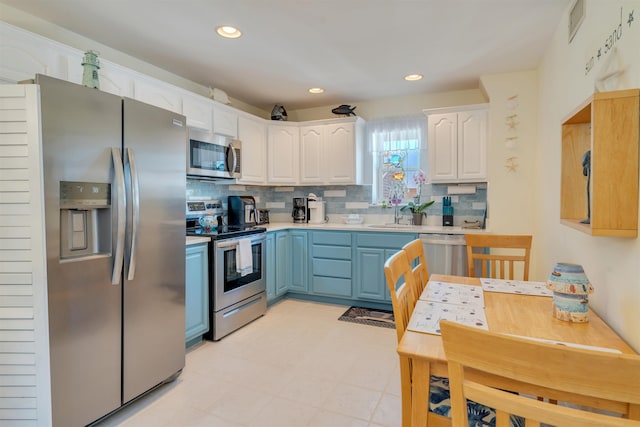 kitchen featuring a sink, white cabinets, light countertops, appliances with stainless steel finishes, and backsplash