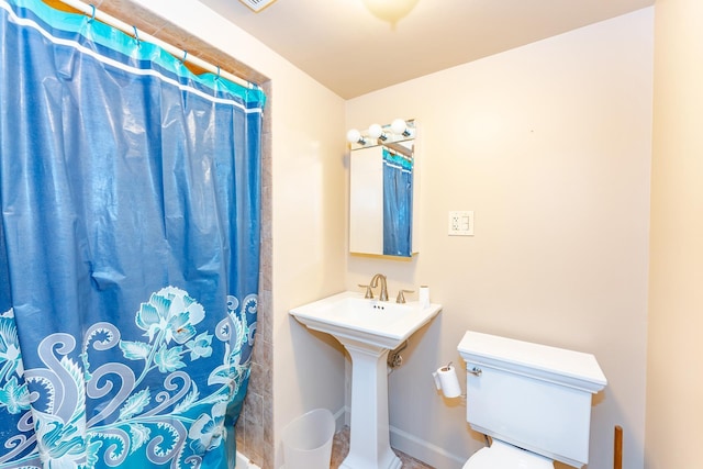 bathroom with toilet and curtained shower