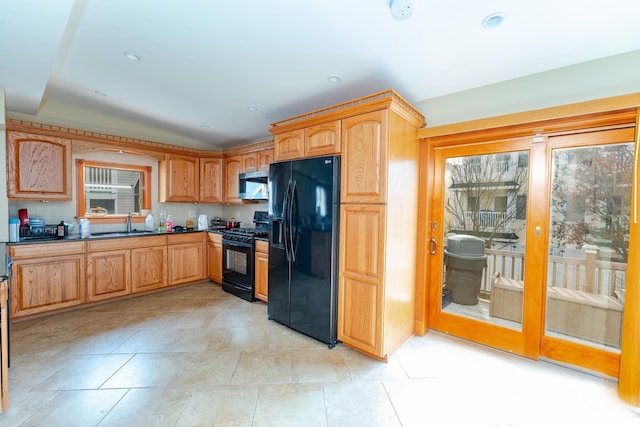 kitchen featuring black appliances, sink, a wealth of natural light, and vaulted ceiling