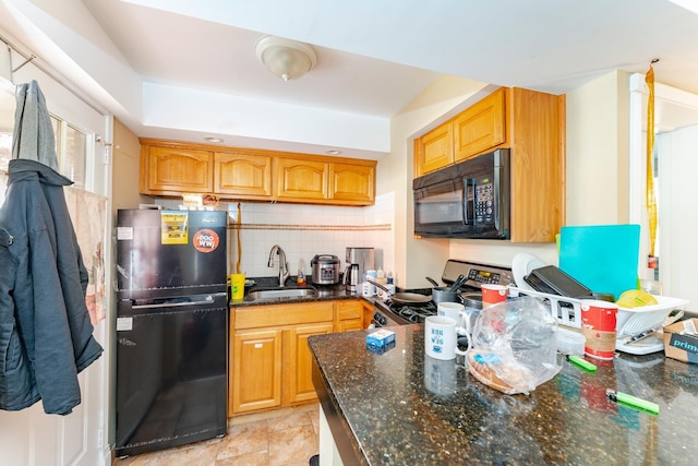 kitchen featuring dark stone countertops, decorative backsplash, sink, and black appliances