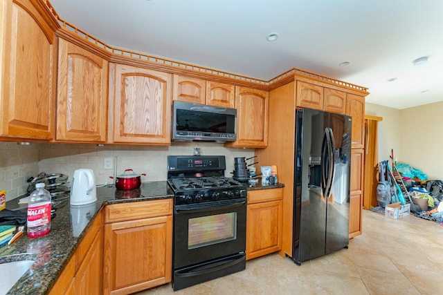 kitchen featuring light tile patterned flooring, decorative backsplash, dark stone countertops, and black appliances