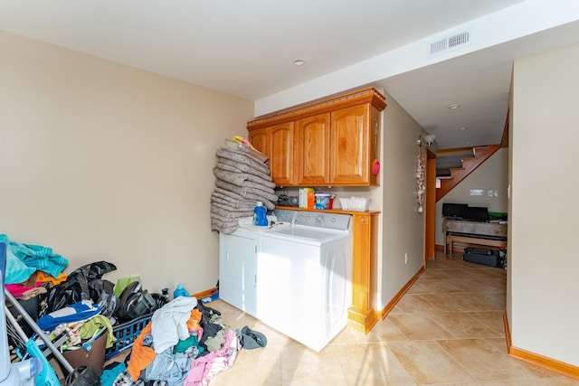 clothes washing area featuring separate washer and dryer and cabinets