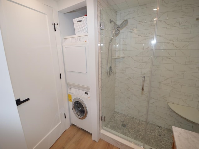177 80th St Unit 104, Avalon, NJ 08202 - bathroom featuring stacked washer and clothes dryer, a stall shower, and wood finished floors