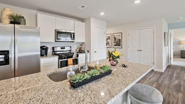 214 Bentz Ave, Villas, NJ 08251 - kitchen featuring stainless steel appliances, a sink, wood finished floors, white cabinets, and recessed lighting