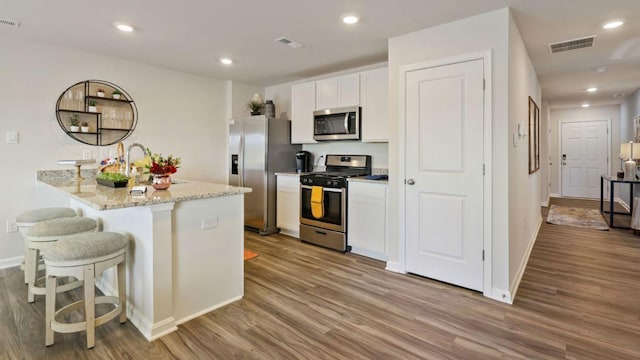214 Bentz Ave, Villas, NJ 08251 - kitchen with appliances with stainless steel finishes, wood finished floors, white cabinetry, a sink, and a breakfast bar area