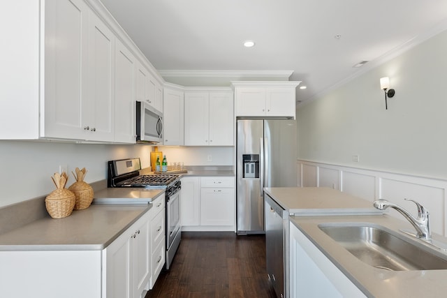 kitchen with white cabinets, appliances with stainless steel finishes, and crown molding