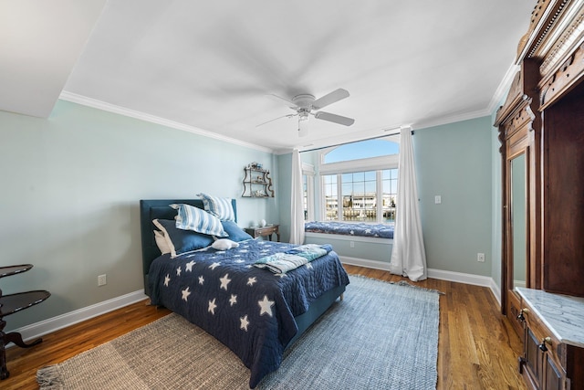 bedroom with a ceiling fan, wood finished floors, baseboards, and ornamental molding