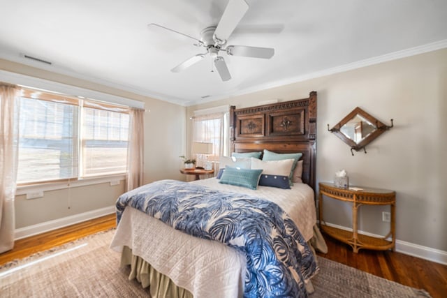 bedroom featuring crown molding, wood finished floors, baseboards, and visible vents