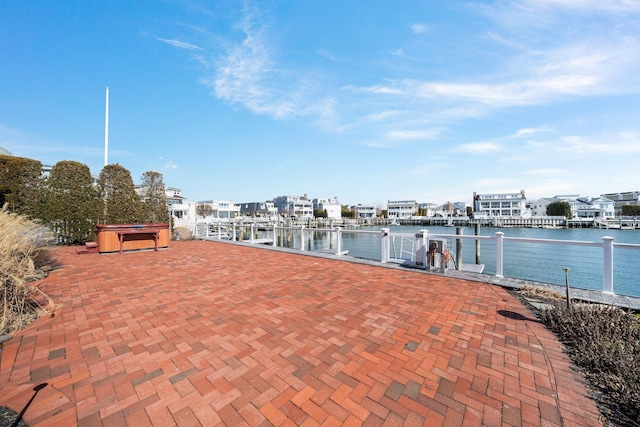 view of patio / terrace featuring a water view and a hot tub