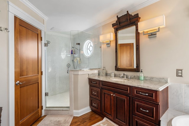 full bathroom with wood finished floors, vanity, a stall shower, and crown molding