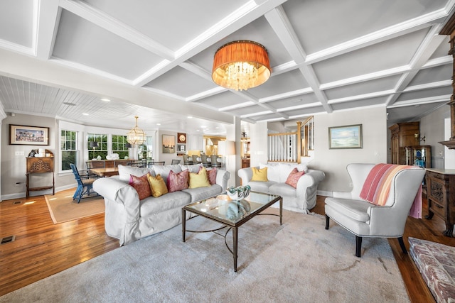 living area featuring a notable chandelier, light wood-style flooring, coffered ceiling, and baseboards