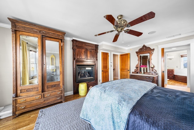 bedroom with visible vents, multiple windows, crown molding, and light wood-type flooring