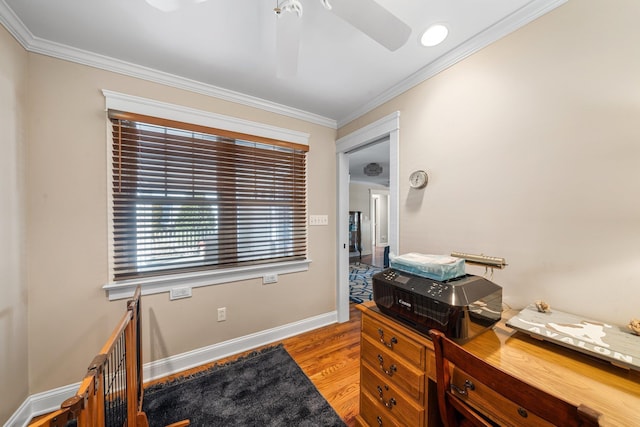 office area featuring a ceiling fan, crown molding, wood finished floors, and baseboards