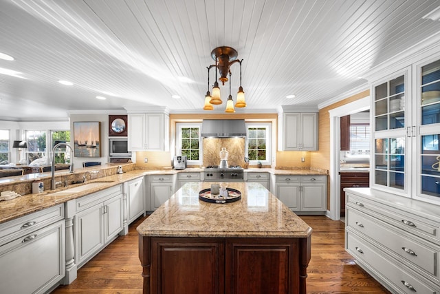 kitchen featuring ornamental molding, wall chimney exhaust hood, dark wood-type flooring, and a sink