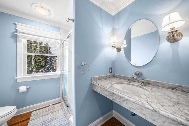 bathroom featuring a sink, baseboards, toilet, and ornamental molding