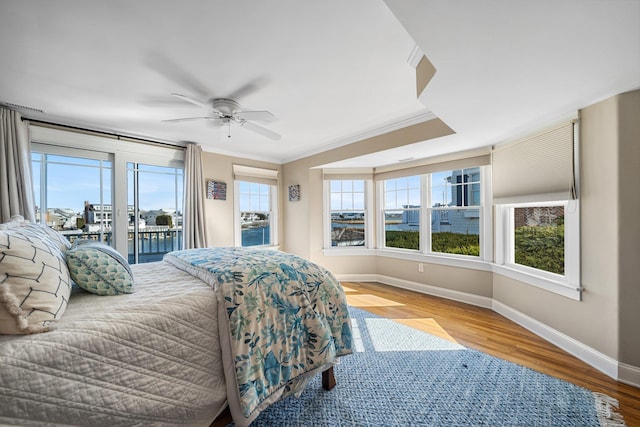 bedroom featuring a ceiling fan, access to outside, wood finished floors, crown molding, and baseboards