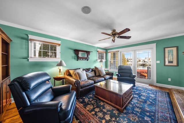 living room featuring ornamental molding, wood finished floors, baseboards, and a healthy amount of sunlight