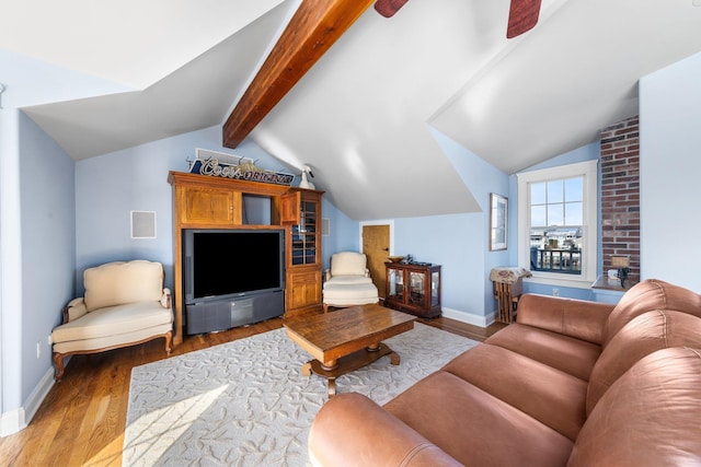 living area with baseboards, ceiling fan, vaulted ceiling with beams, and light wood-style floors