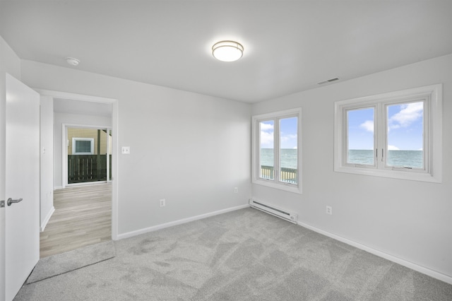 carpeted empty room with baseboard heating and a water view