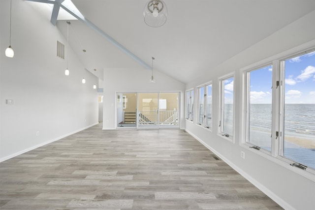 unfurnished sunroom featuring a water view and lofted ceiling