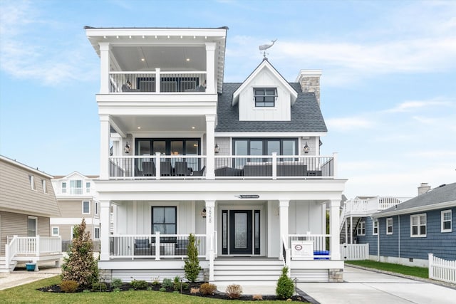 2958 Avalon Ave, Avalon, NJ 08202 - view of front facade featuring a balcony, board and batten siding, a porch, and a chimney