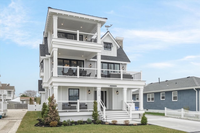 2958 Avalon Ave, Avalon, NJ 08202 - view of front of house with a balcony, board and batten siding, covered porch, and a chimney