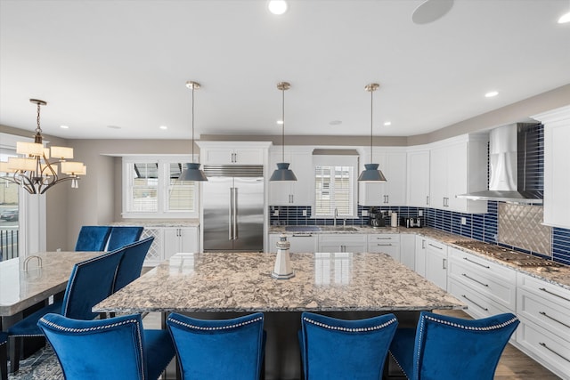 2958 Avalon Ave, Avalon, NJ 08202 - kitchen with built in fridge, wall chimney range hood, gas cooktop, a chandelier, and a center island